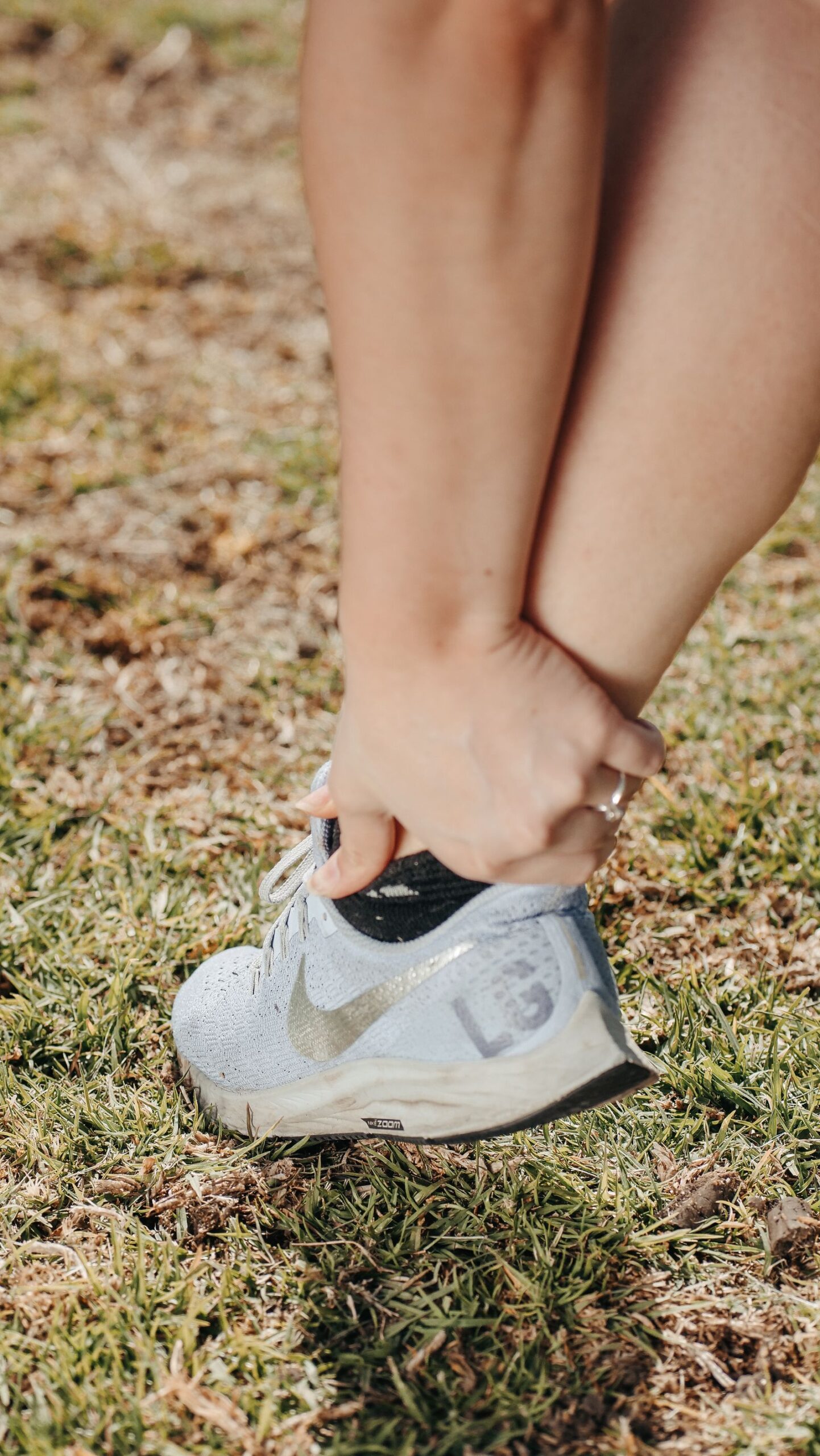 Runner holding ankle near the Achilles tendon, tendon recovery care in Hinsdale, IL