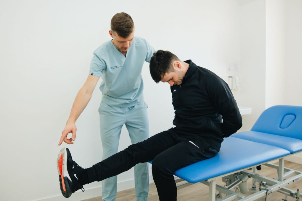 Patient doing a guided hamstring and calf stretch with a clinician, part of recovery after shockwave therapy in Hinsdale