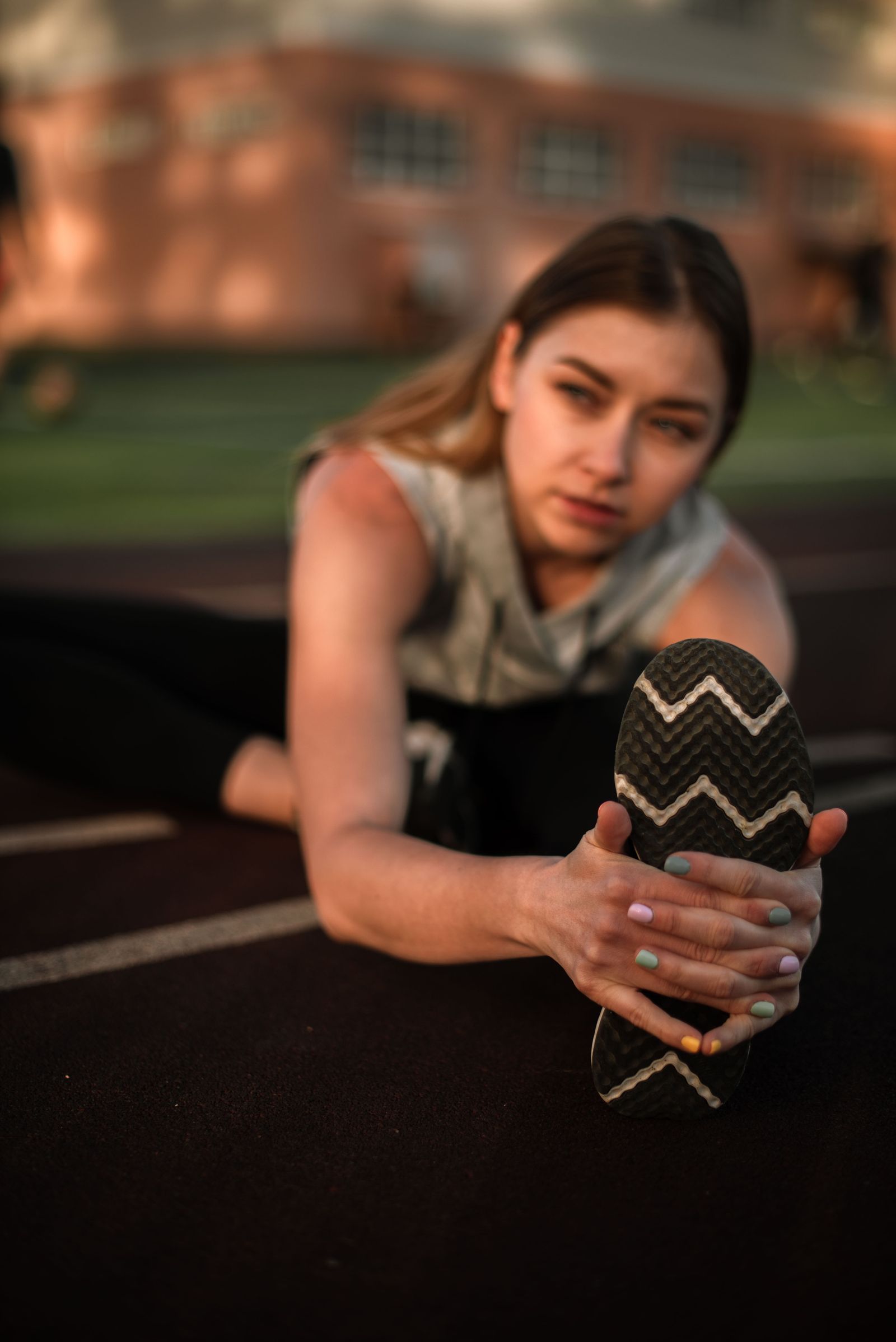 Woman stretching her foot by pulling her toes back toward her shin, a plantar fascia stretch that boosts shockwave results for heel pain in Hinsdale, IL