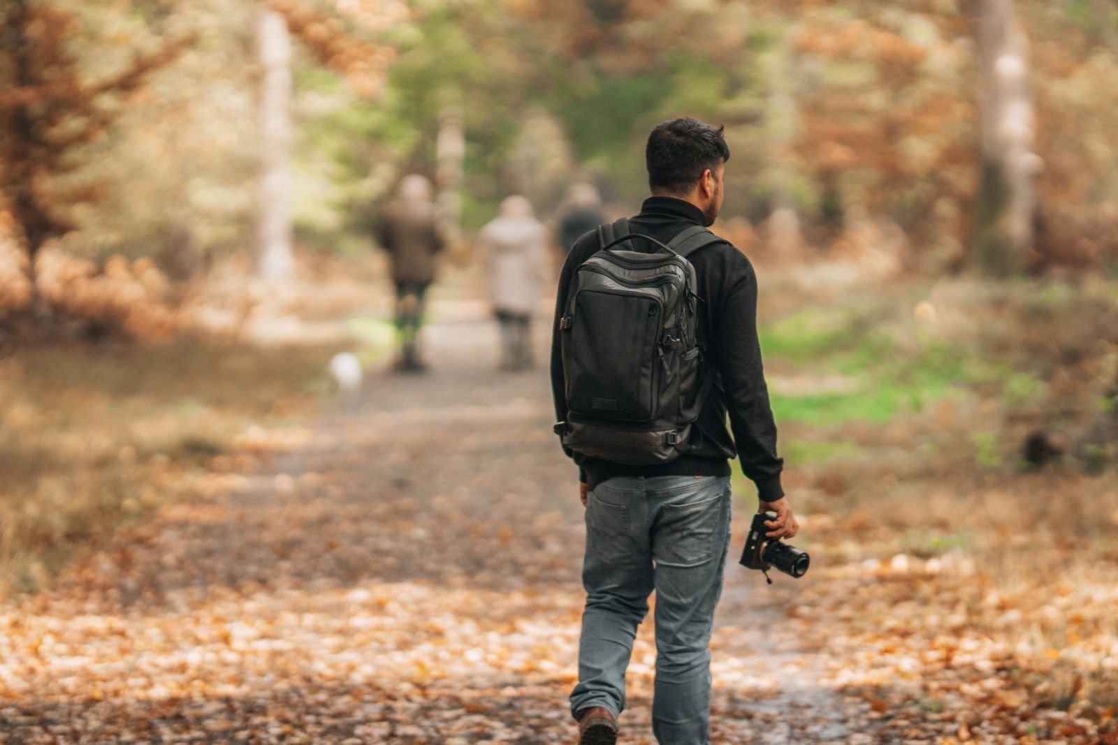 Man walking comfortably on an autumn park path, back to everyday activity after Achilles tendinitis treatment in Hinsdale, IL